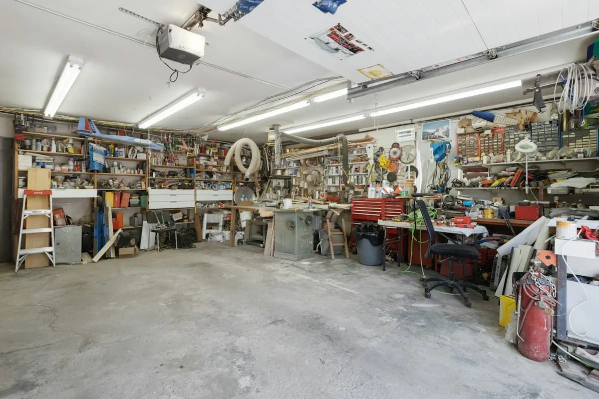 Large garage workshop with shelving and a bare concrete floor