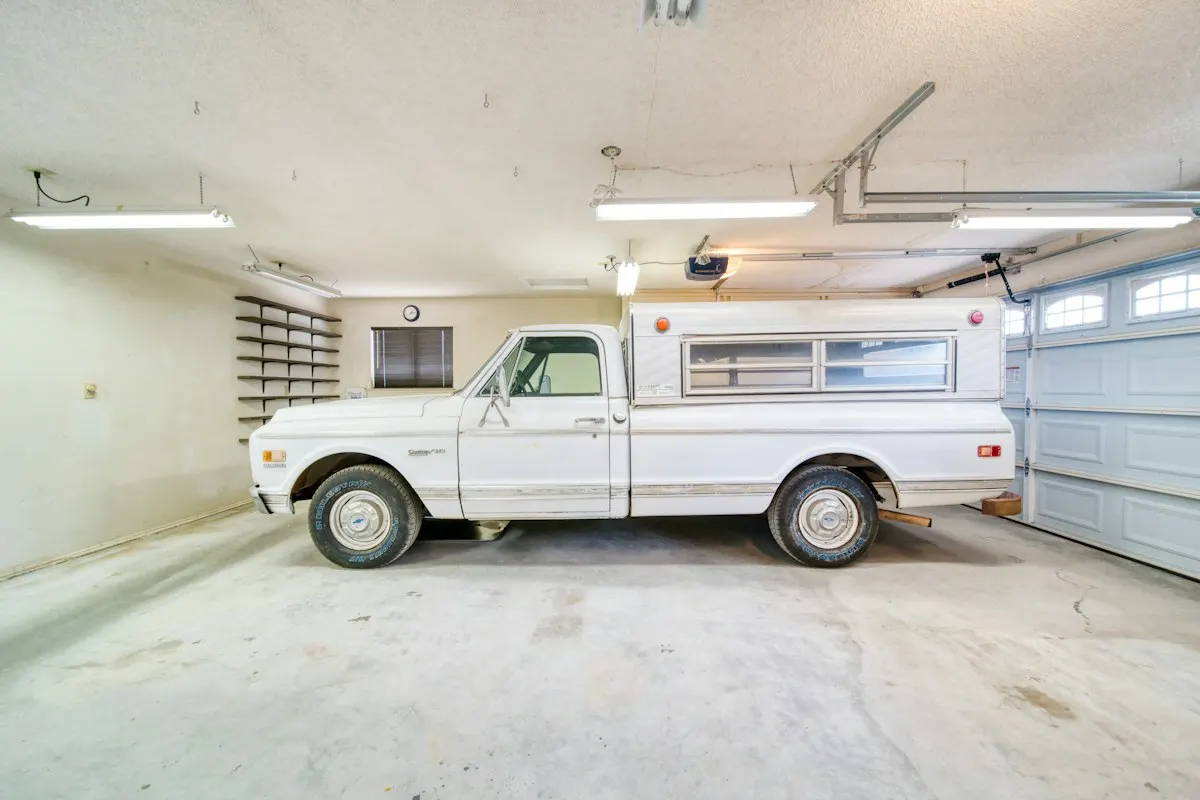 Residential garage with a light concrete floor and parked pickup