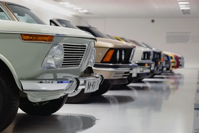 Row of classic cars on a glossy light-grey floor