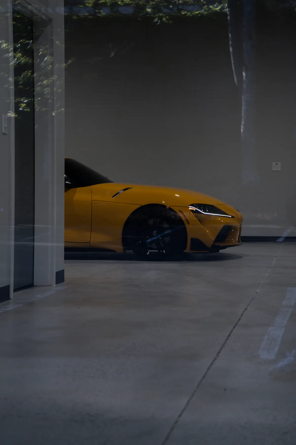 Parked car beside a light grey garage floor